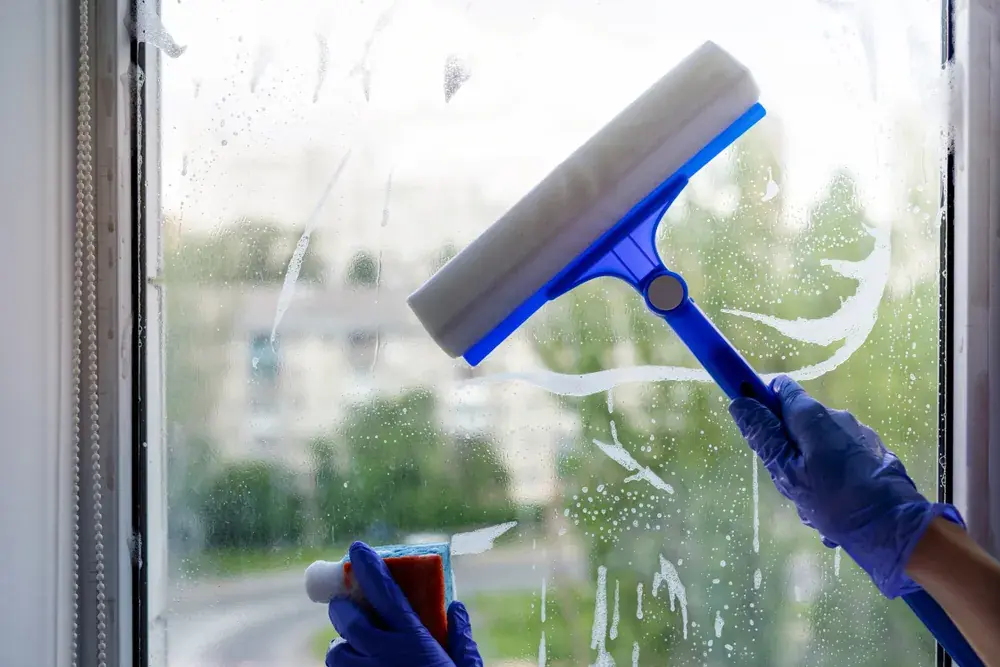 Window being cleaned with a squeegee and cleaning solution